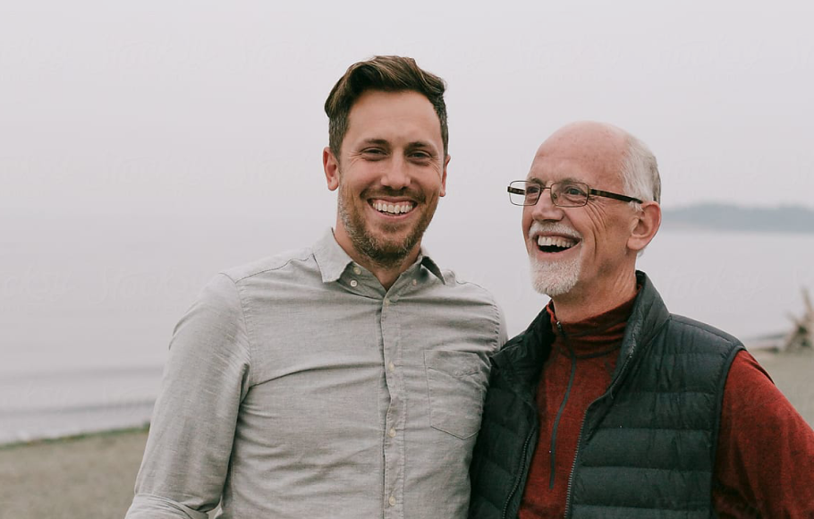 father and son on beach smiling