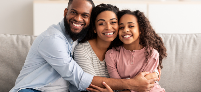 family sitting on couch smiling
